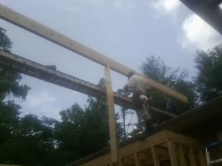 Carpenter setting a ridge beam over a new addition frame — Ice Dam Removal by Roofing Brothers in Lake Harmony