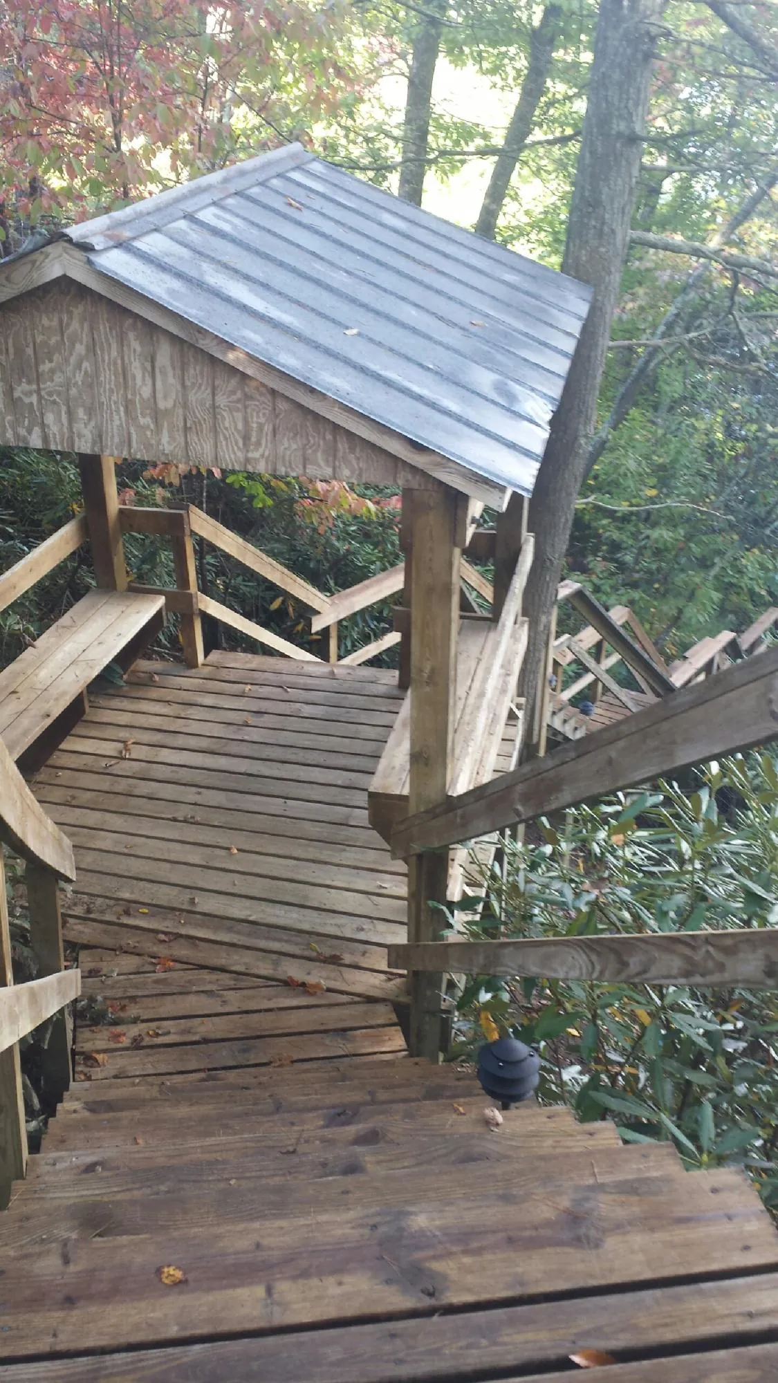 Metal roofed shelter over wooden steps on a wooded walkway — Skylight Repair & Installation work by our crew in Lake Harmony