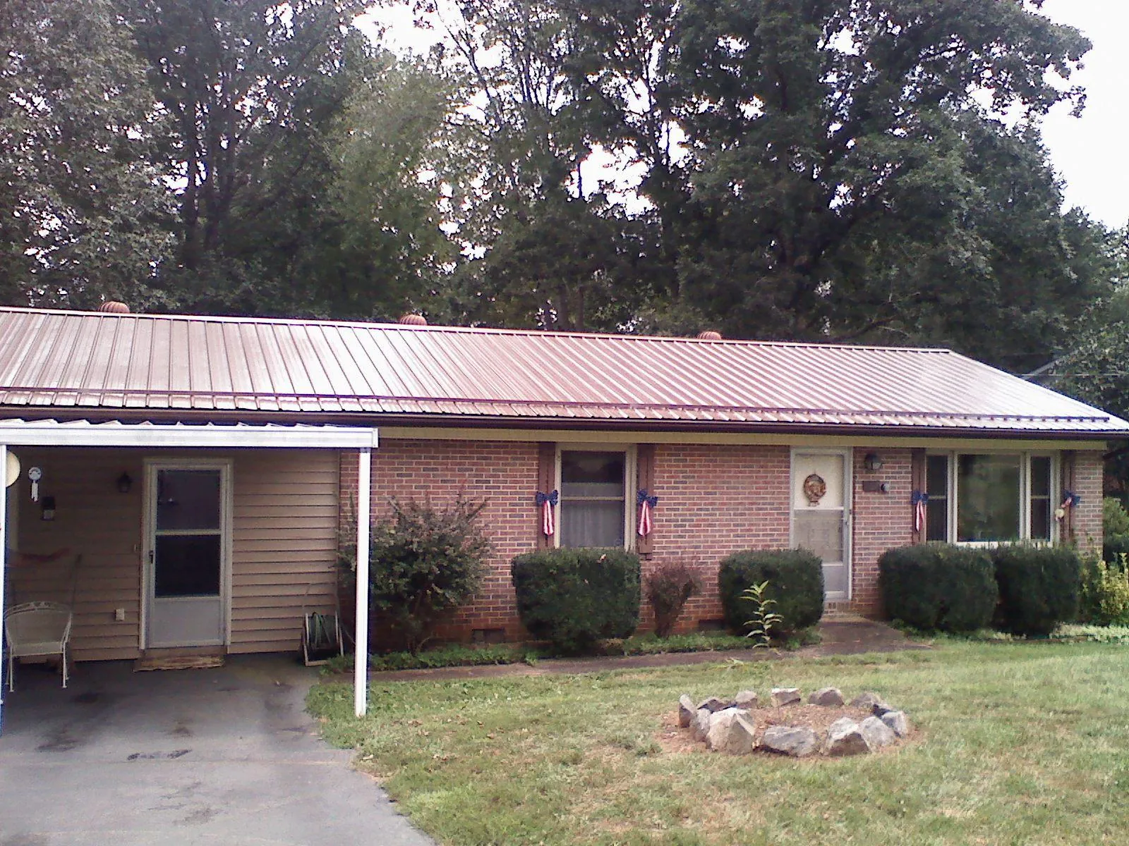Bronze metal roof and carport on a brick ranch home — Roof Repair work by our crew in Lake Harmony